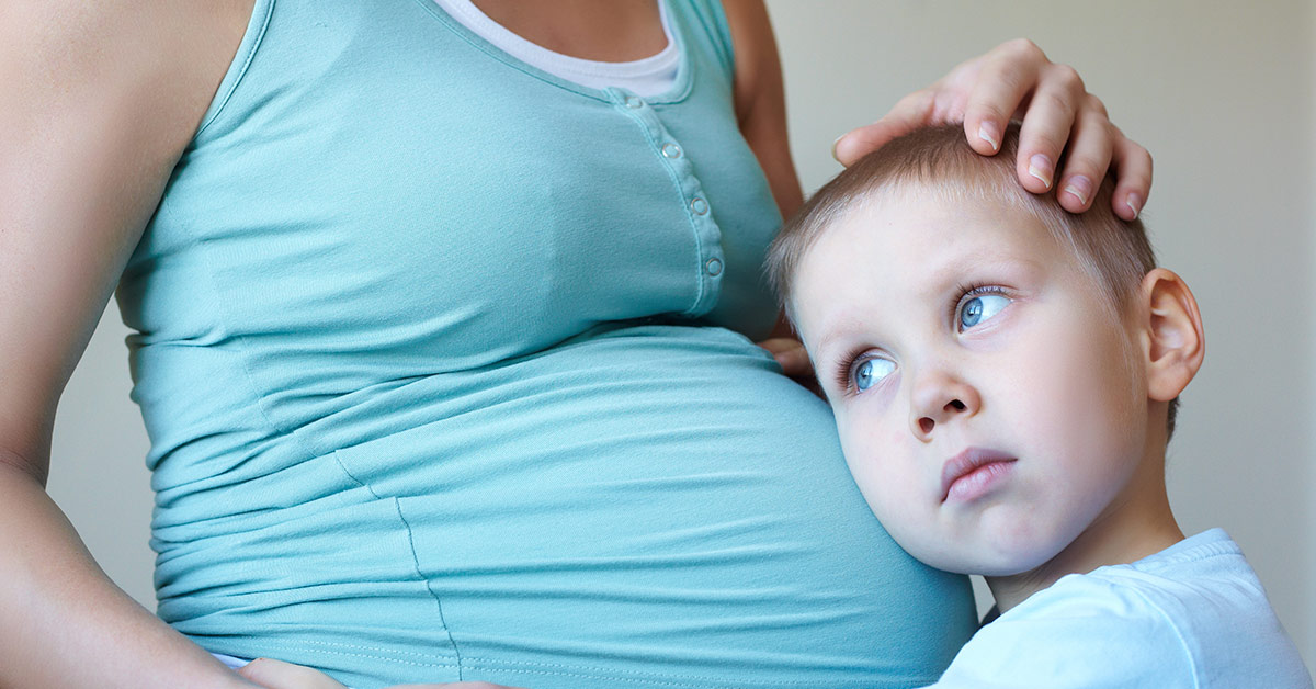 boy hugging pregnant mother