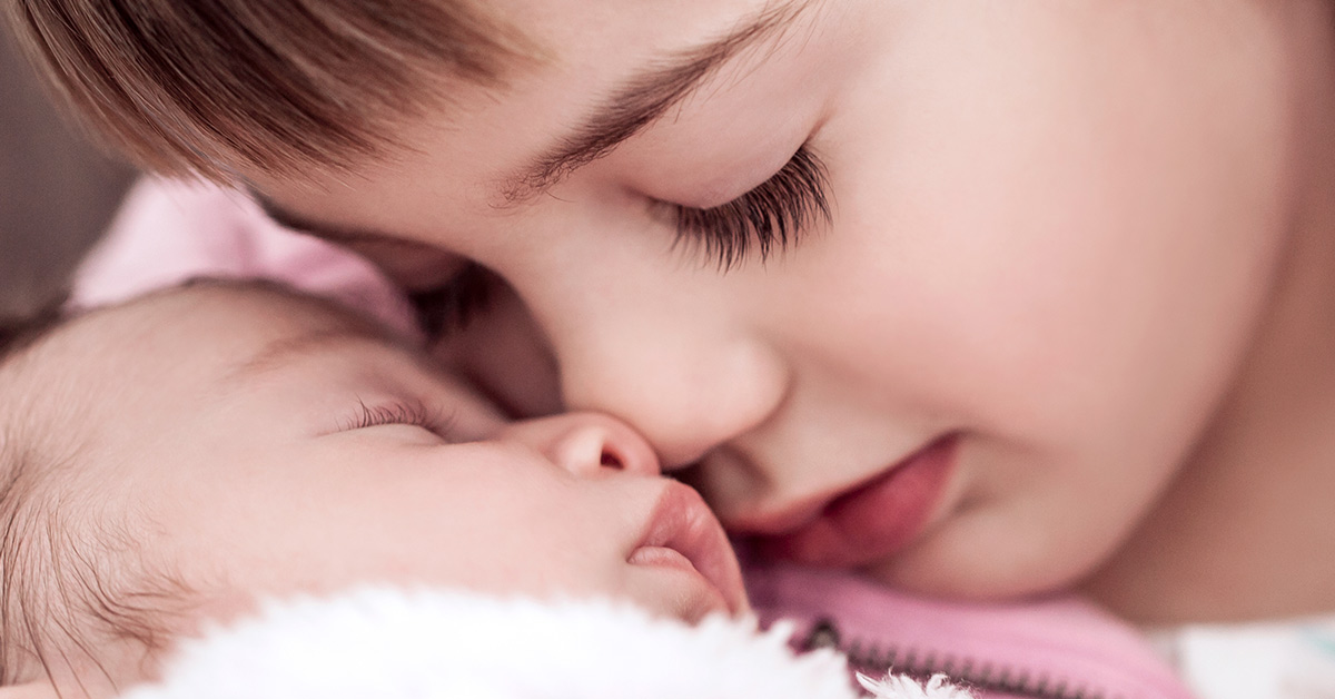 Close up of siblings closely hugging