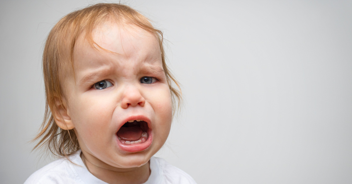 a blond baby who looks like they're about to cry