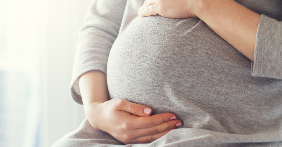 pregnant person holding belly