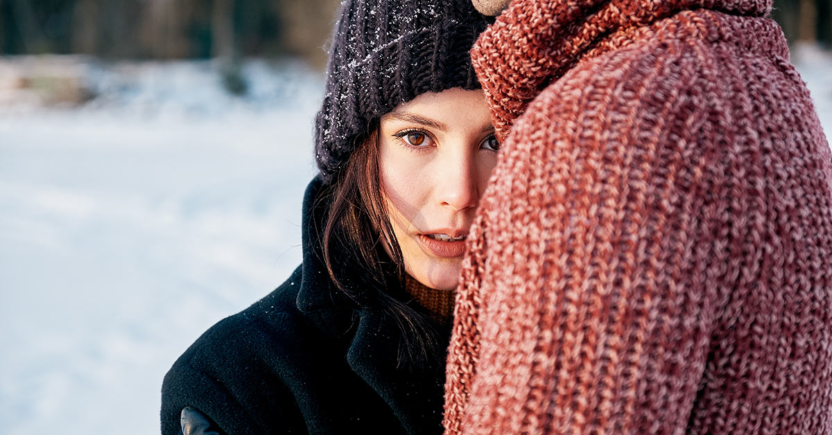 woman outside on a winter day, she is putting hear head against the chest of her partner