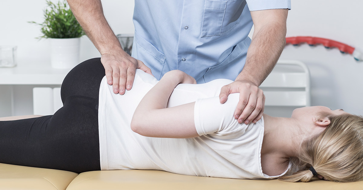 chiropractor giving a woman laying down an adjustment