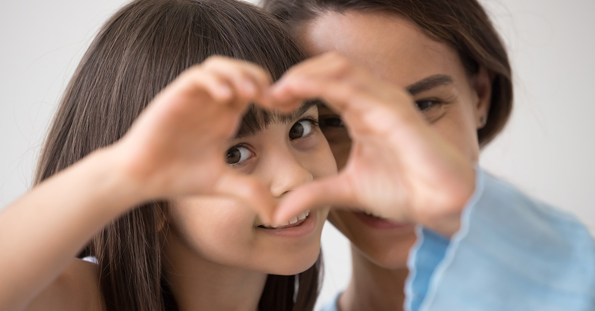 girl putting hands together to make the shape of a heart