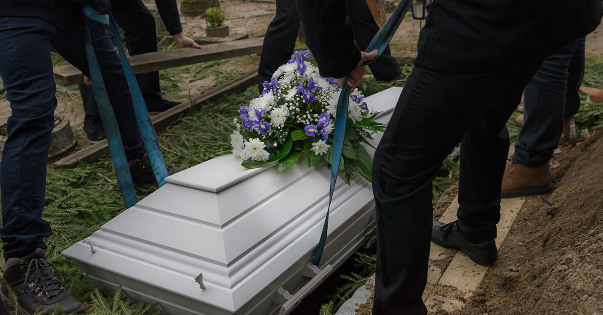 casket being lowered into ground during funeral
