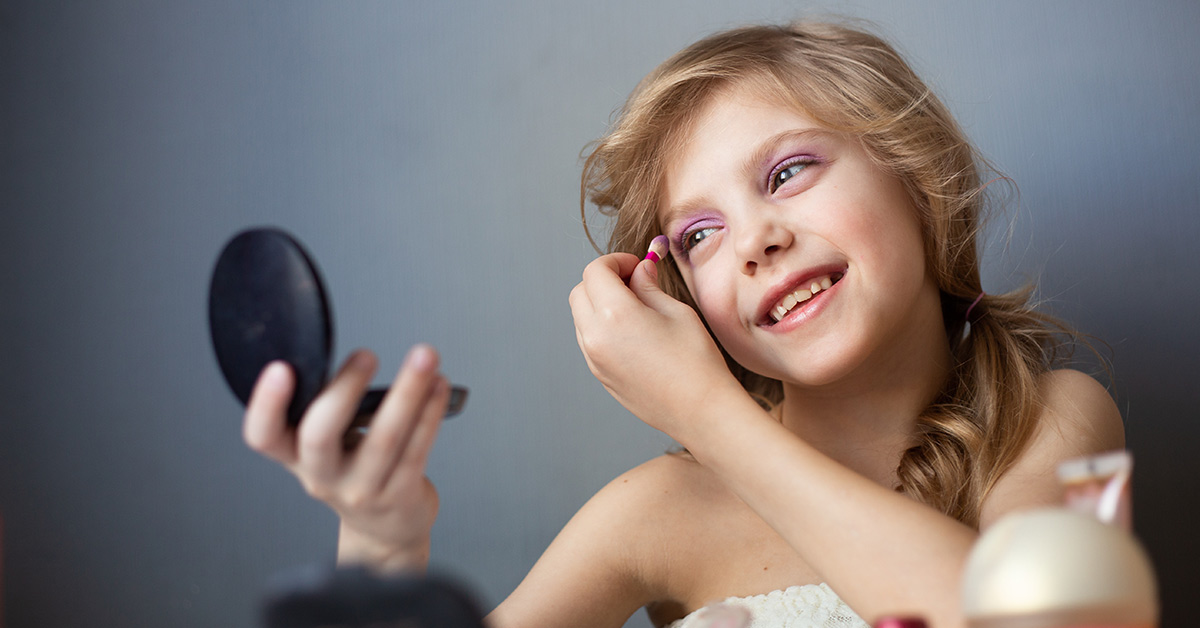 young girl applying make up