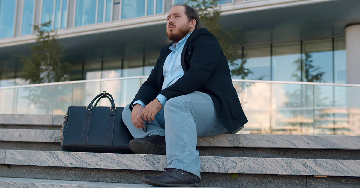 man sitting on marble steps in front of an office building