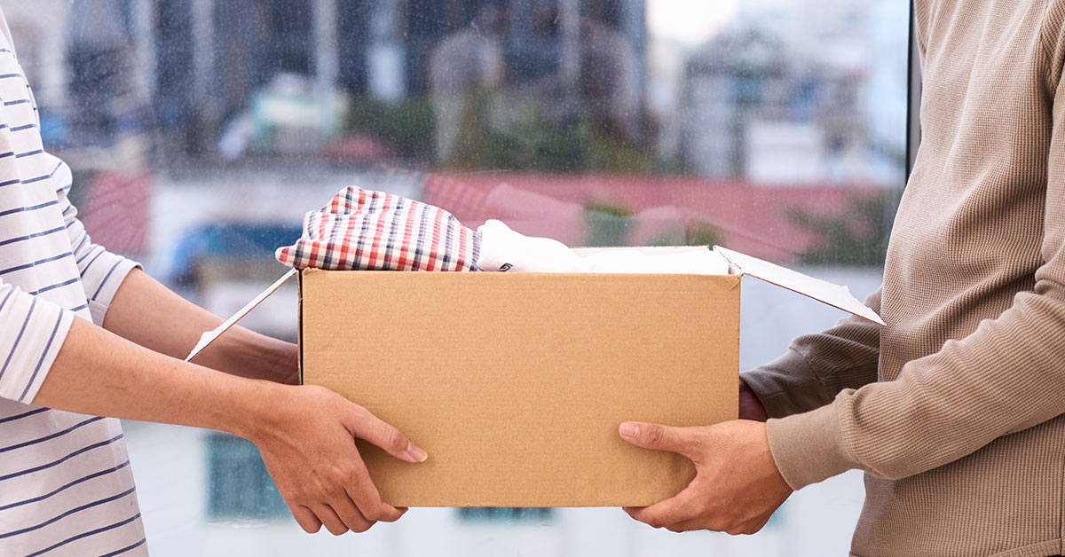 box filled with items being handed between two people