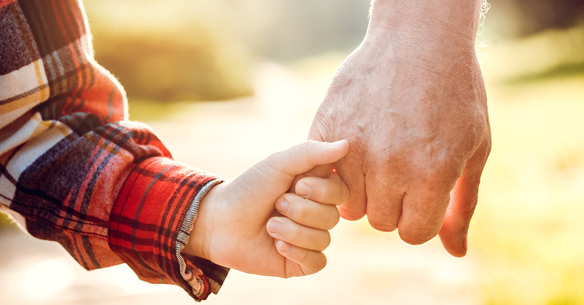 toddlers hand holding the finger of an adult