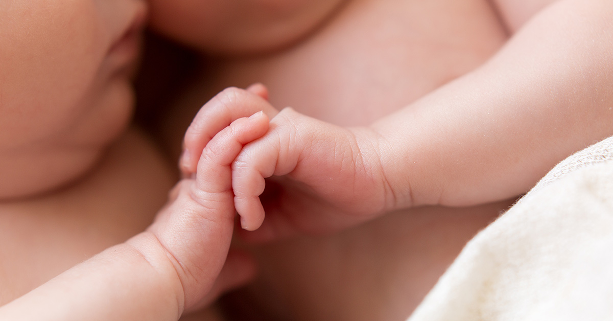 infants holding hands