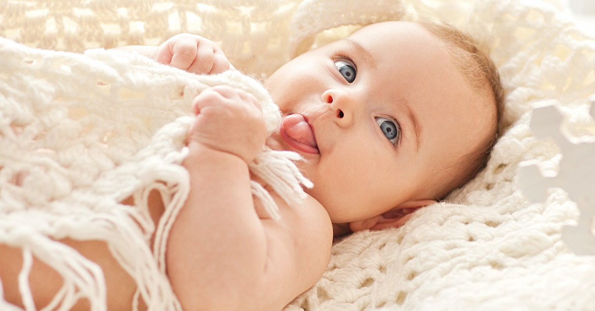 infant laying on white bedding