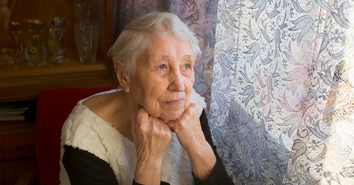elderly woman looking out a window