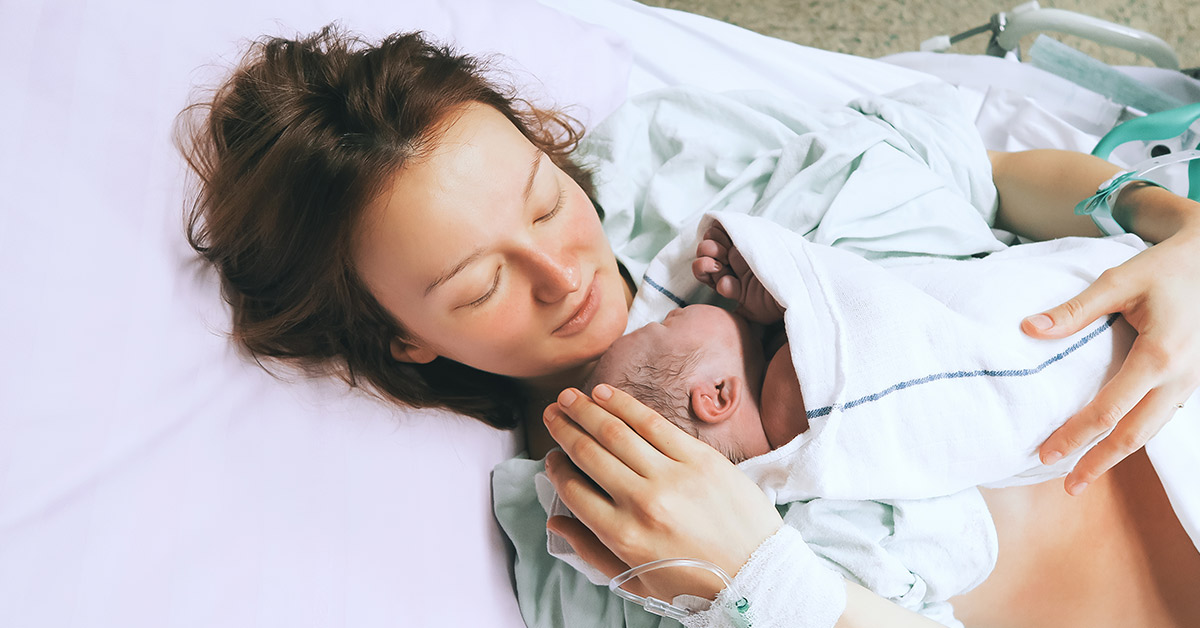 mother in hospital bed holding her newborn child
