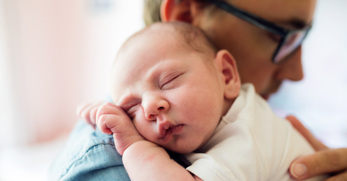 infant sleeping on fathers shoulder