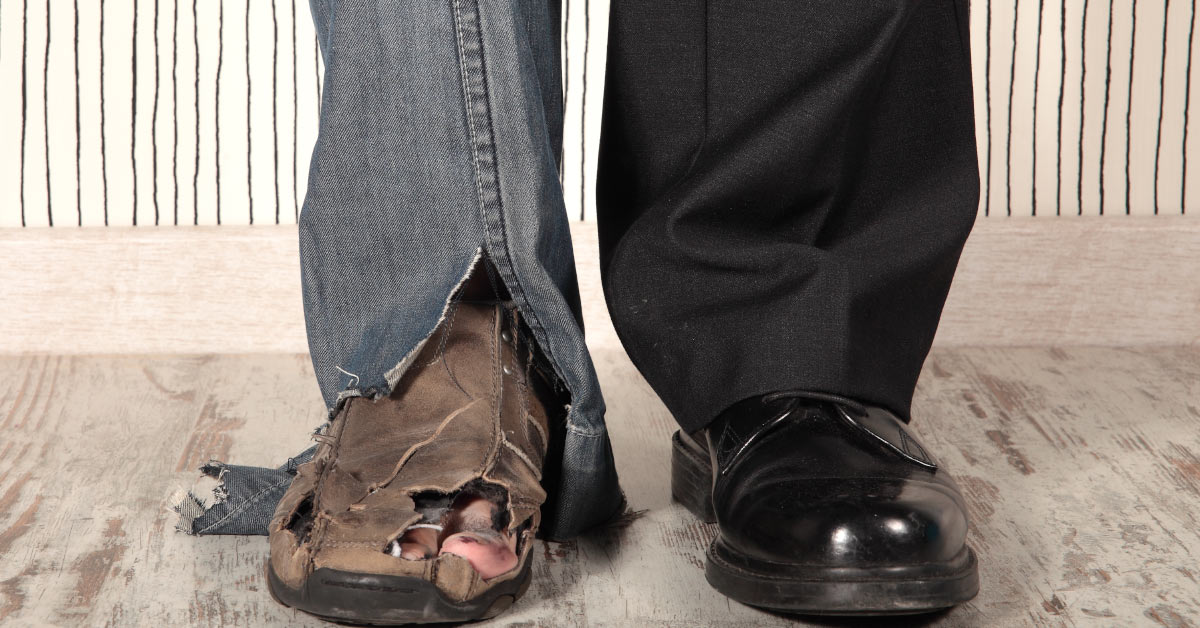 s set of legs with one weaing tattered jeans and a old torn shoes. The other left has black business pants and shoes.