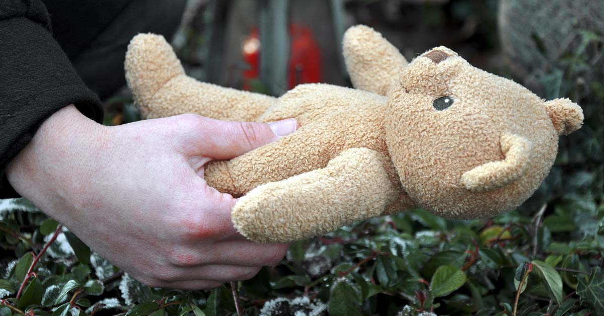 hand holding a small stuffed teddy bear