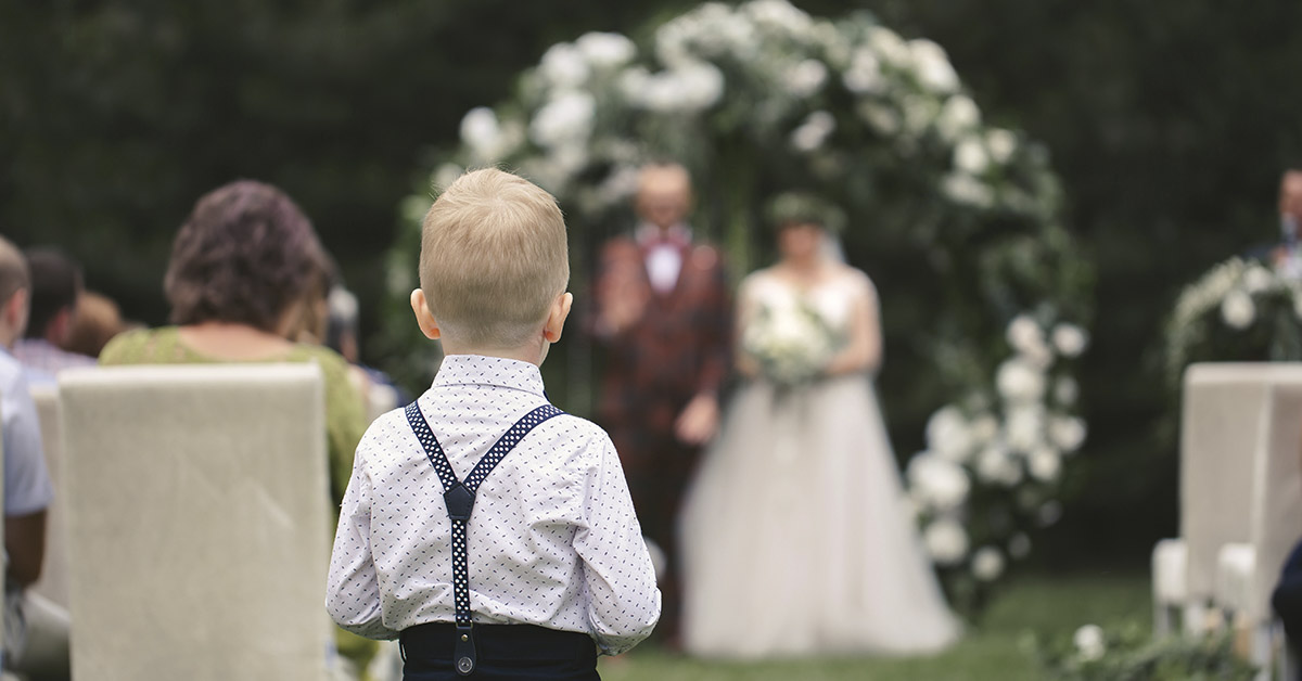 toddler boy walking down aisle at wedding