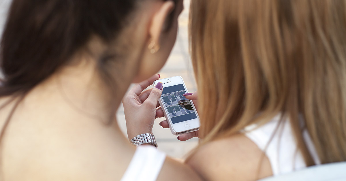 teen girls using a smartphone to access social media