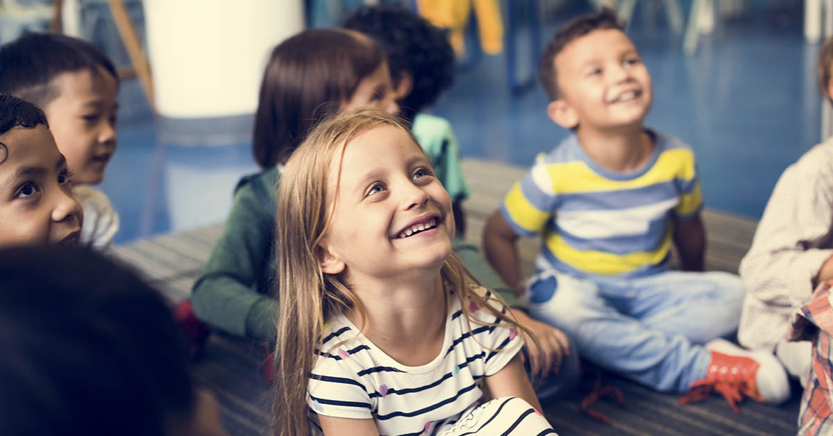 young children sitting on floor cross legged