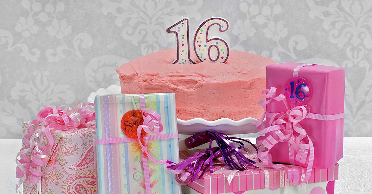 16th birthday cake with gifts placed around