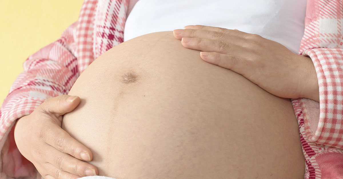 woman holding her pregnant belly