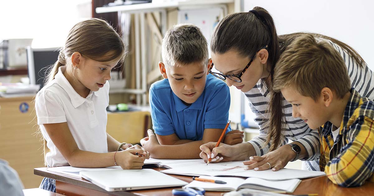 young children in educational setting being helped by teacher