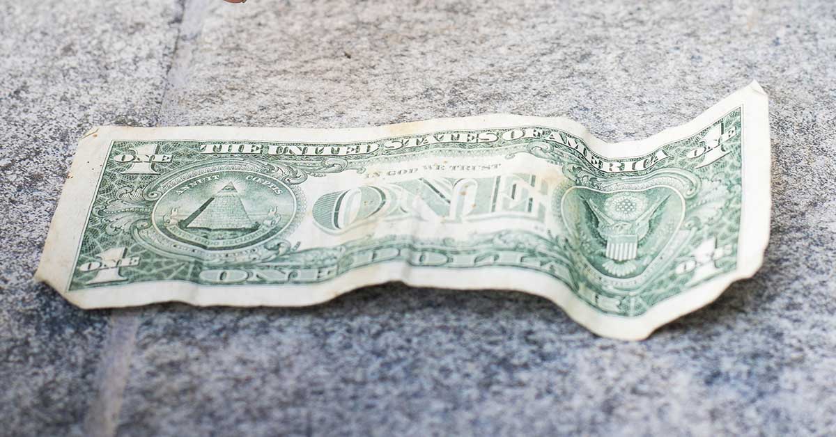 US dollar pill on pavement