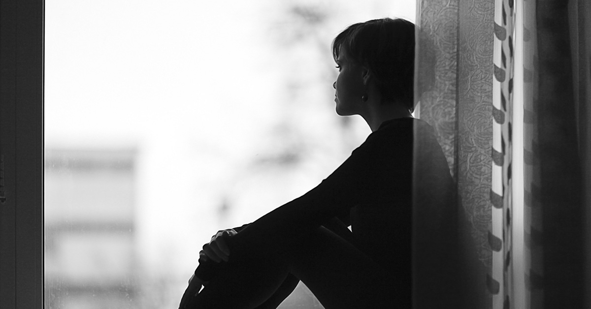 out of focus silhouette of person gazing out a window