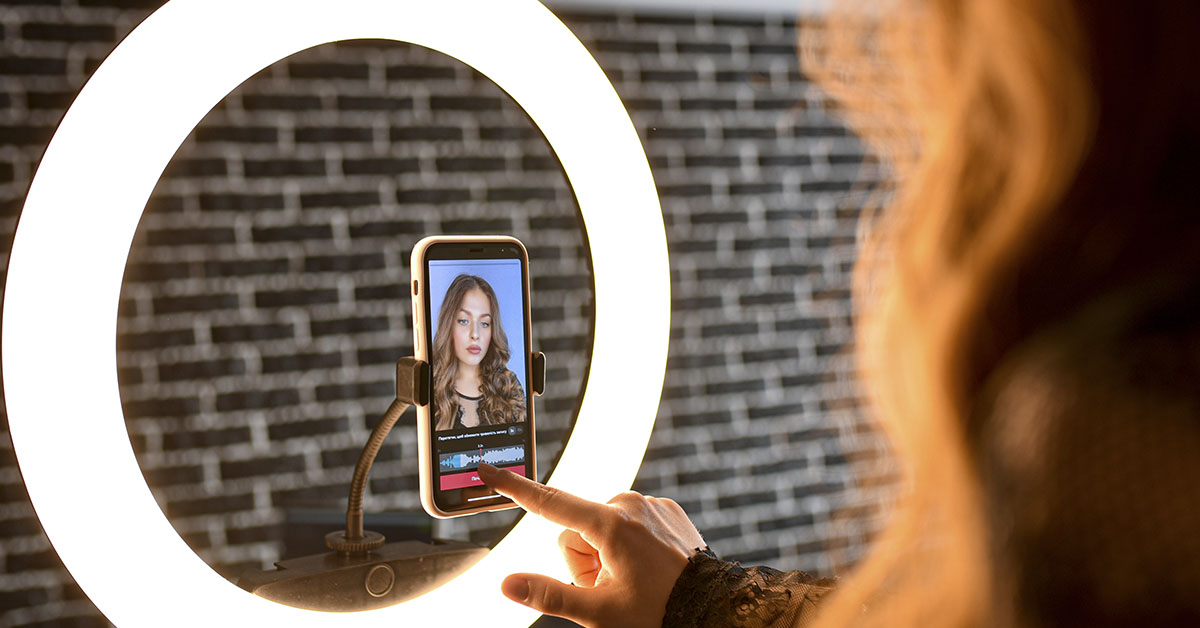 woman using ring light around smartphone
