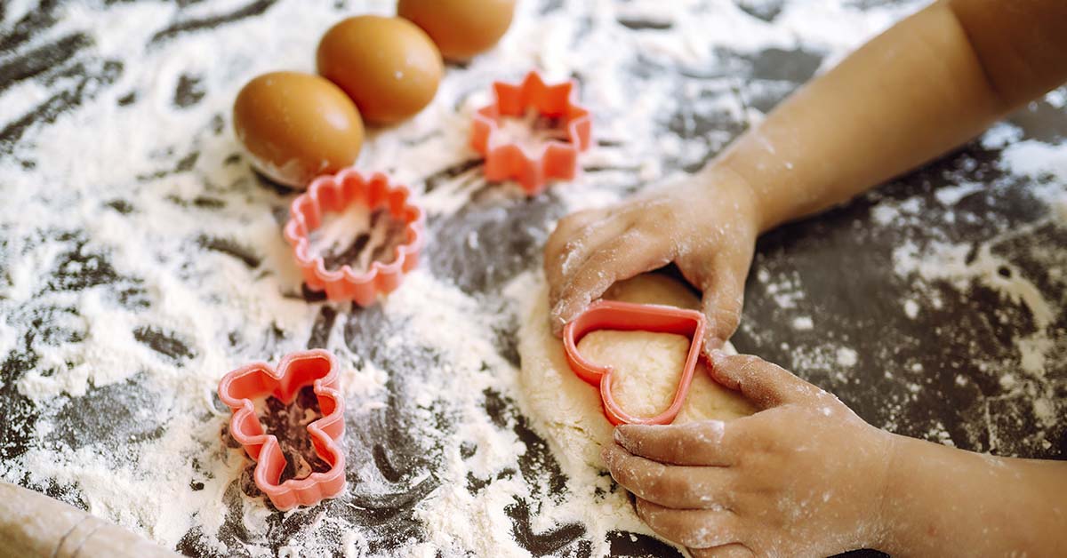 child baking using cookie cutters