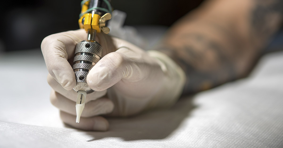 hand holding tattoo gun
