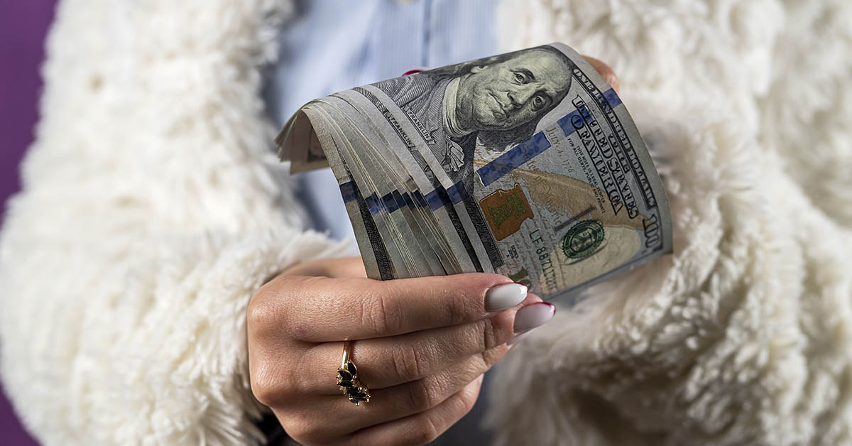 woman holding wad of cash