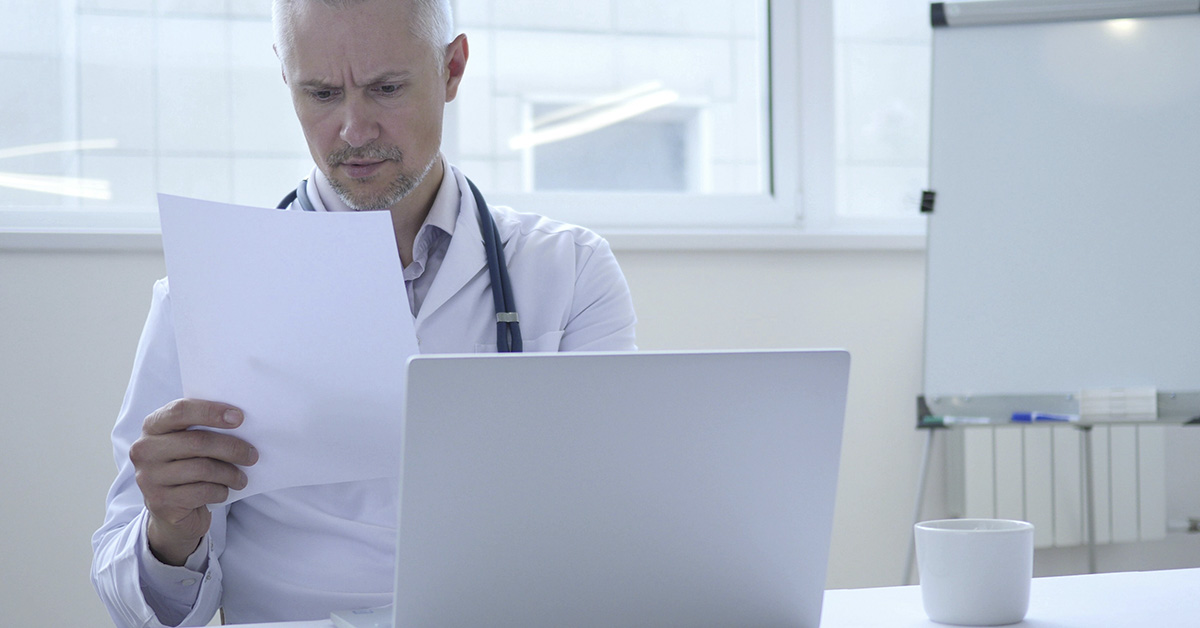 doctor at desk looking at patient files