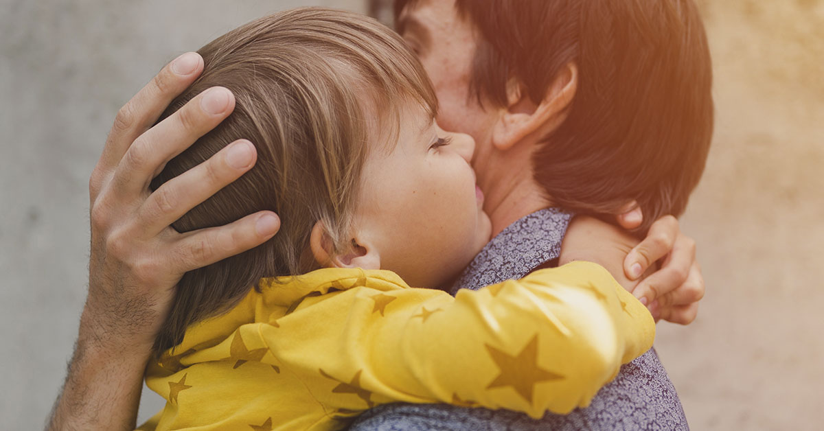 young boy embracing his father