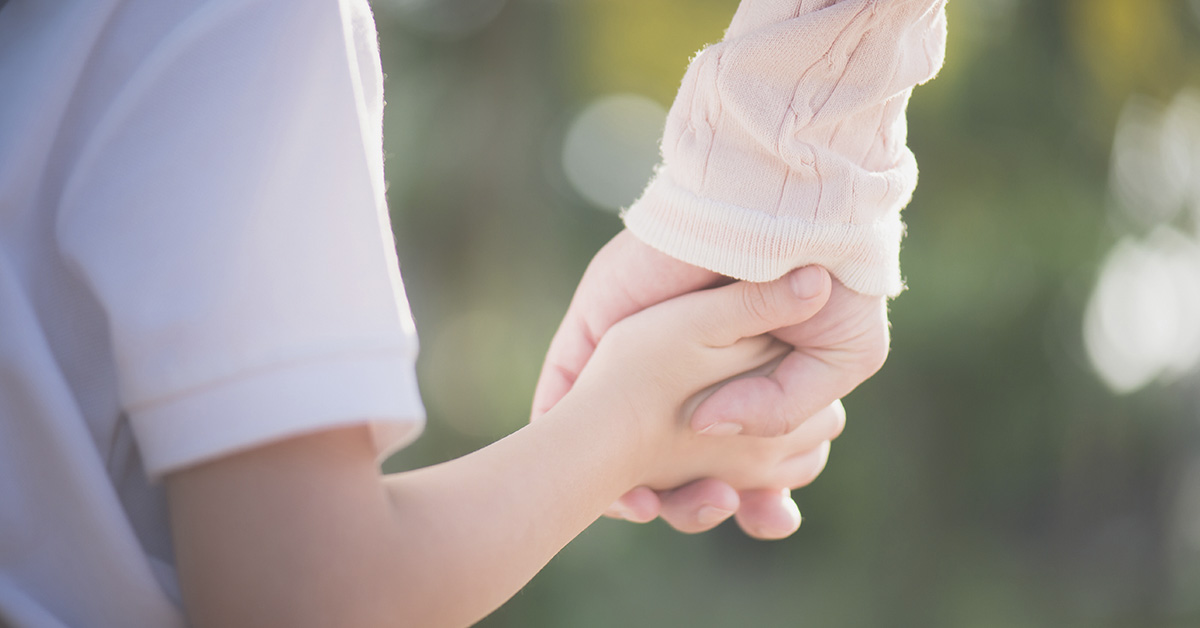 mother holding child's hand