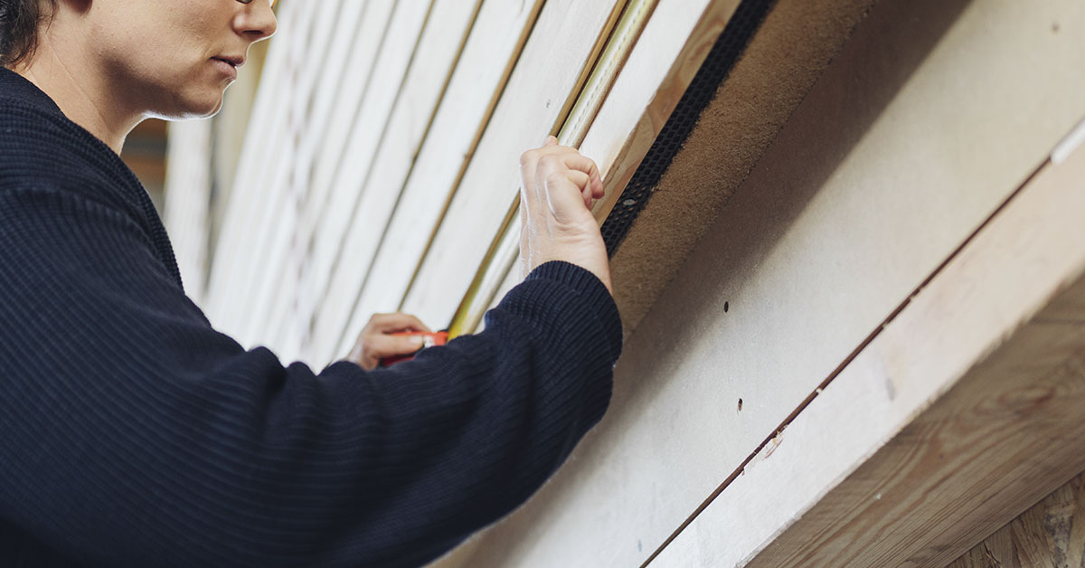 woman putting siding on home