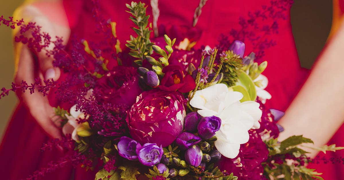 woman wearing a red dress holding a bouquet of flowers