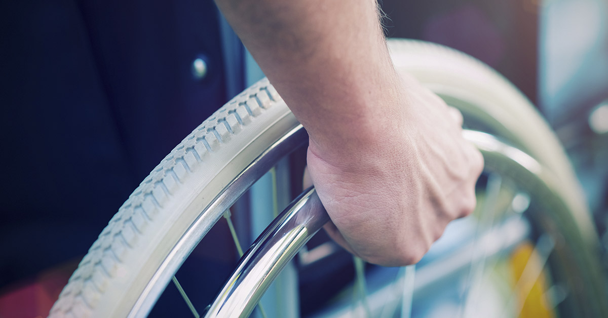 hand placed on wheel of wheelchair