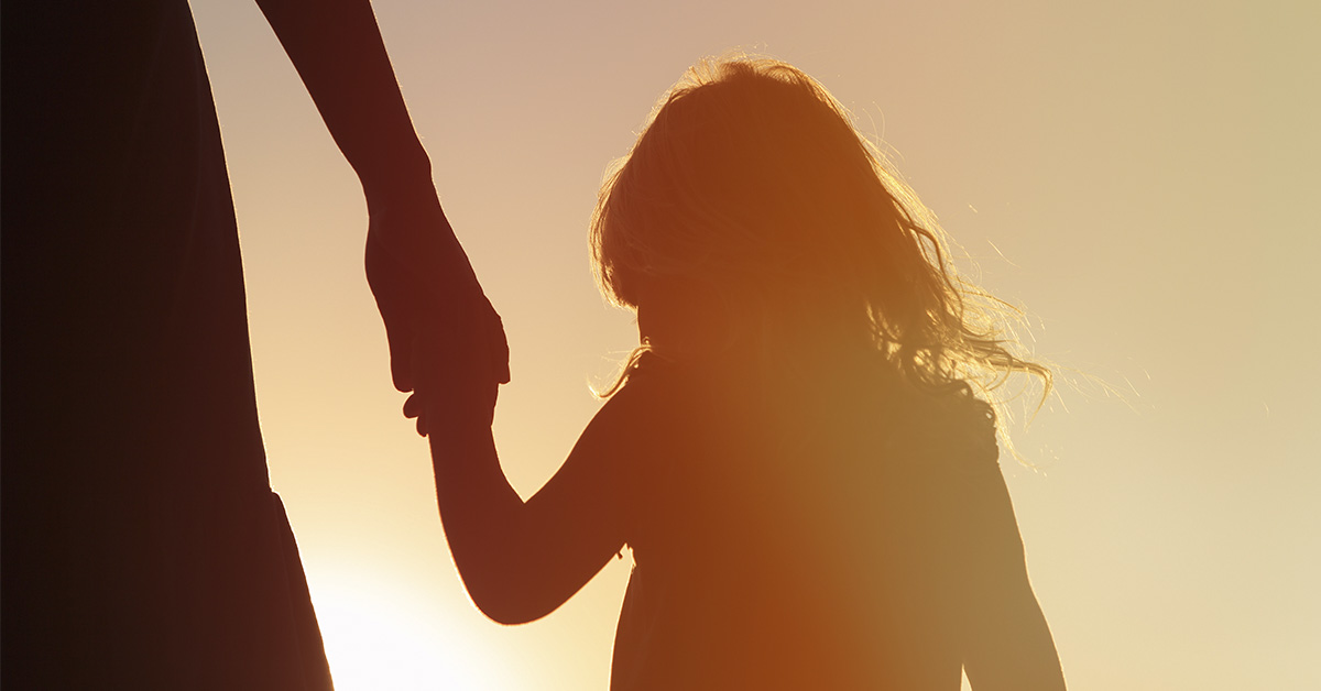 silhouette of parent holding daughters hand