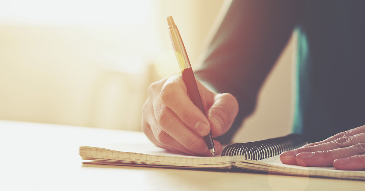 person writing in notebook. Writing a note