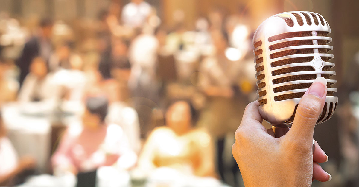 speaking into microphone to crowd