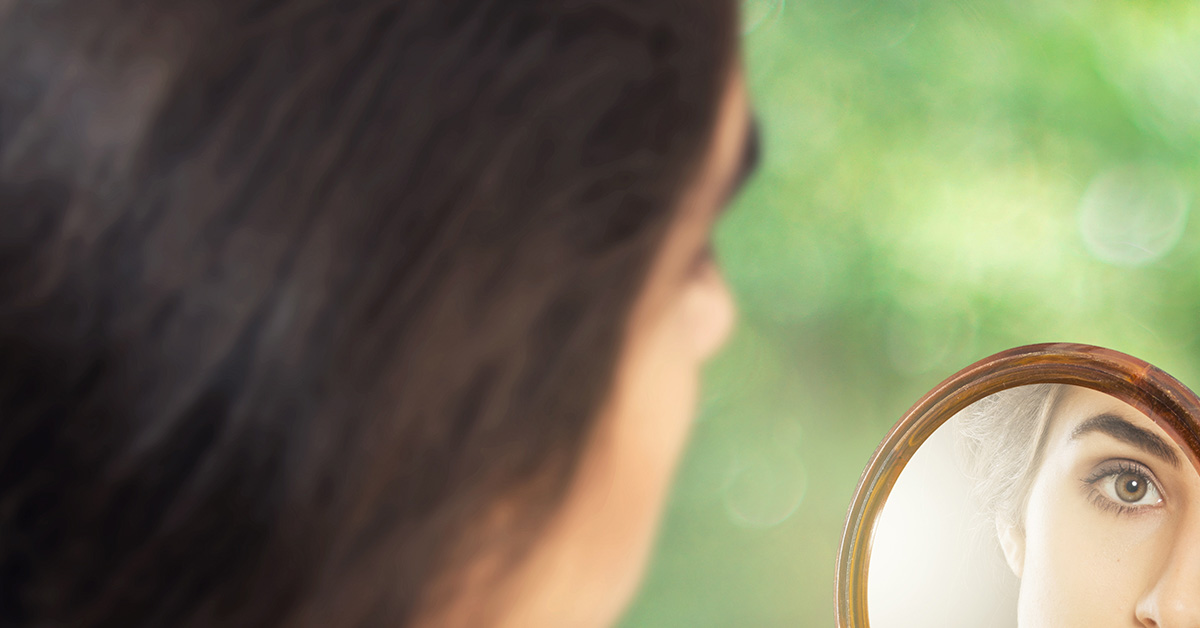 woman looking in mirror