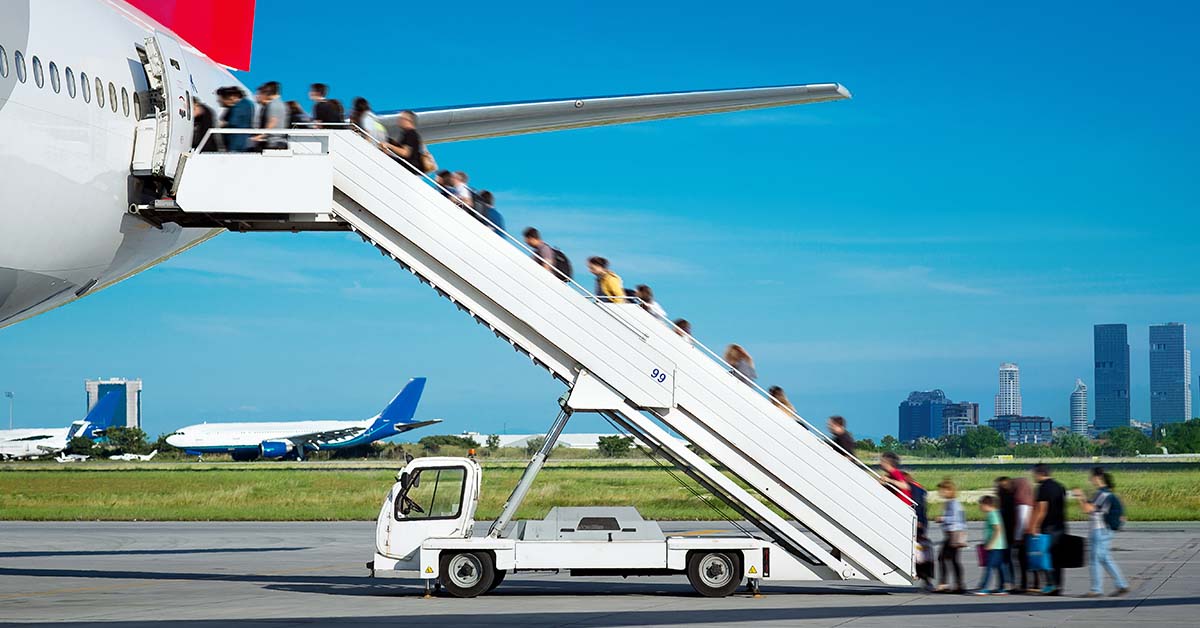 passengers boarding a plane via passenger steps