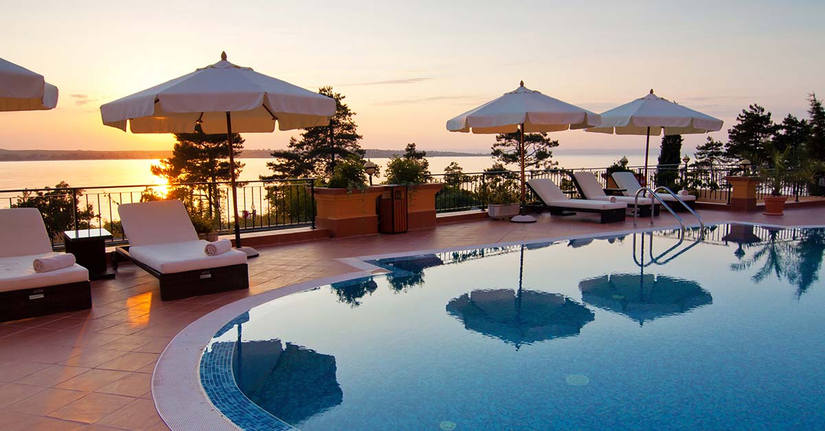 pool at resort surrounded by sun chairs and umbrellas