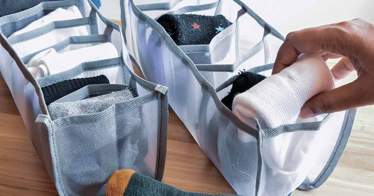 Woman organizing her socks in storage organiser compartment boxes. Housework, lifestyle concept.