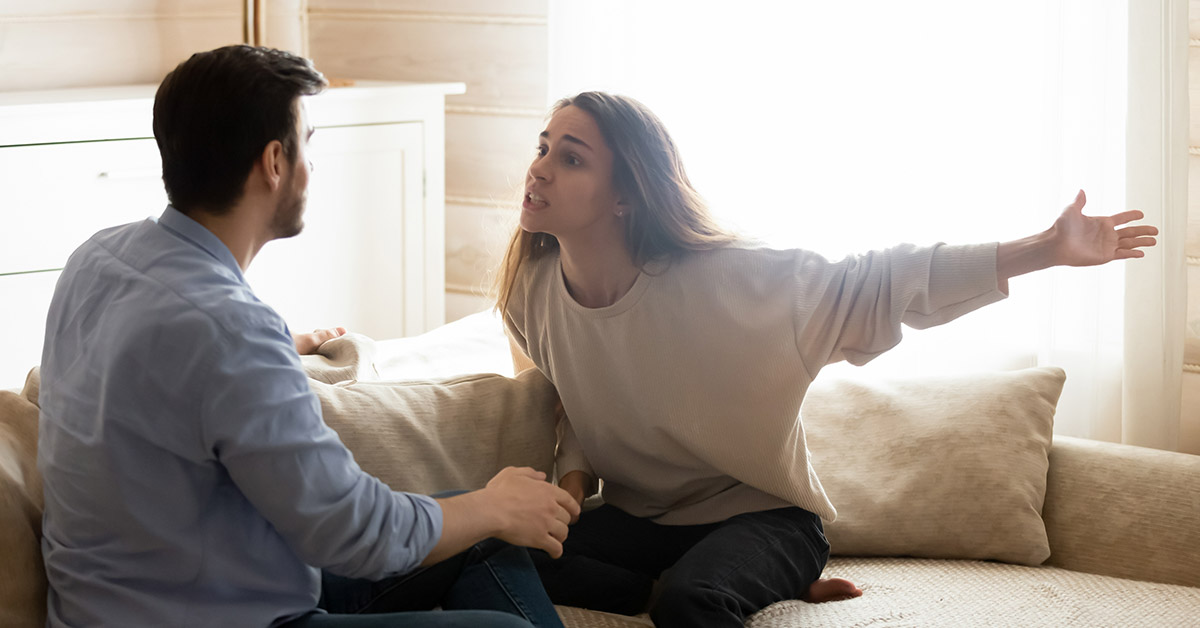 couple sitting on a couch in fight