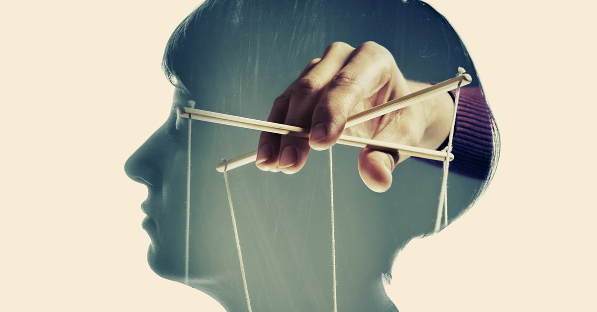 silhouette of woman's head with person manipulating a marionette. Manipulation concept