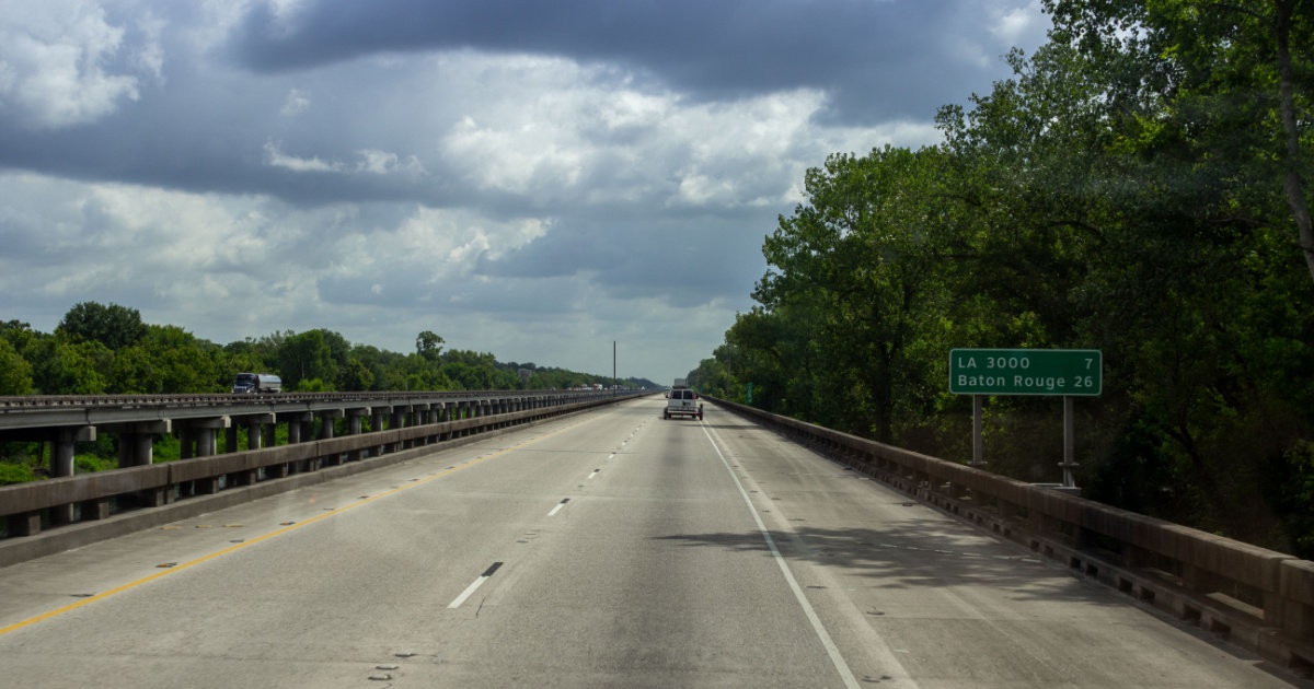 The road, a long bridge on which cars ride on a sunny summer day. Summer on the roads of Louisiana, USA. Interstate 10