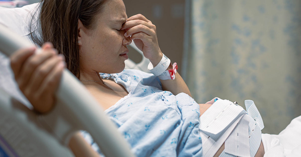 A depressed pregnant woman worried about her baby, in the hospital clinic.