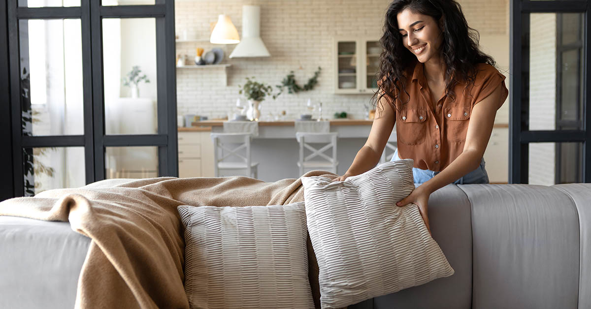 woman arranging pillows on a couch