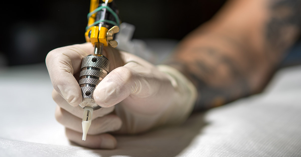 tattoo artist holding a tattoo gun